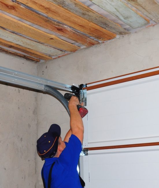 Contractor Installing Garage Door Post Rail and Spring Installa
